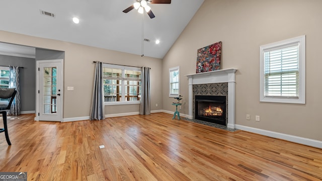 unfurnished living room with high vaulted ceiling, a wealth of natural light, light hardwood / wood-style floors, and ceiling fan