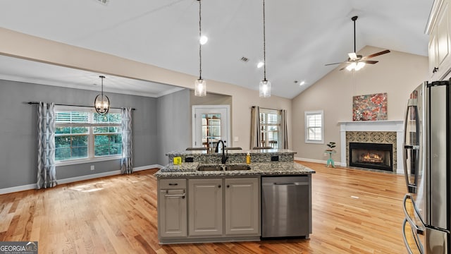 kitchen featuring sink, hanging light fixtures, dark stone counters, gray cabinets, and stainless steel appliances