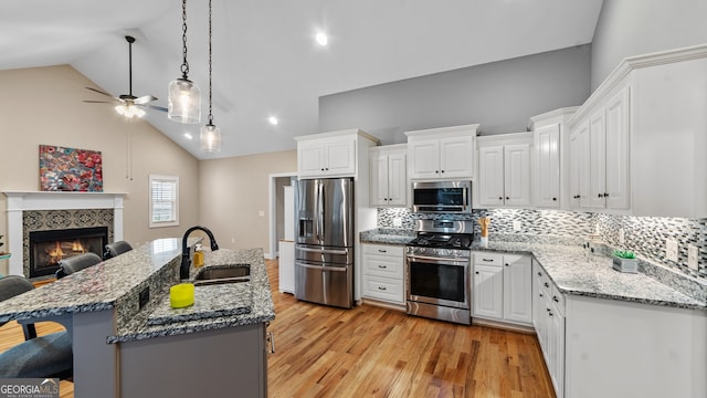 kitchen featuring sink, white cabinetry, a kitchen breakfast bar, a kitchen island, and stainless steel appliances