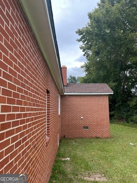 view of side of home with a lawn