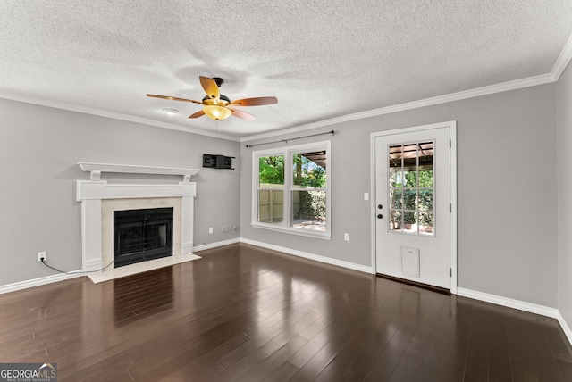 unfurnished living room featuring dark wood-type flooring, crown molding, ceiling fan, a textured ceiling, and a fireplace