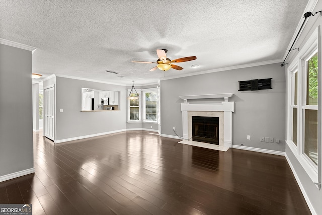 unfurnished living room featuring a textured ceiling, dark hardwood / wood-style floors, and a healthy amount of sunlight