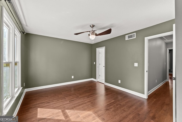 spare room featuring a wealth of natural light, dark hardwood / wood-style flooring, and ceiling fan