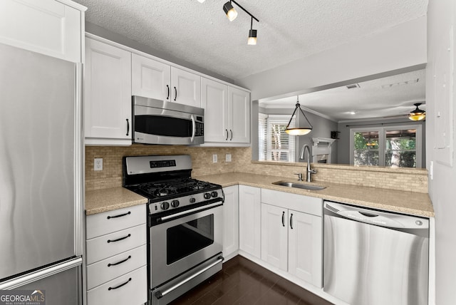 kitchen with backsplash, white cabinetry, sink, and appliances with stainless steel finishes