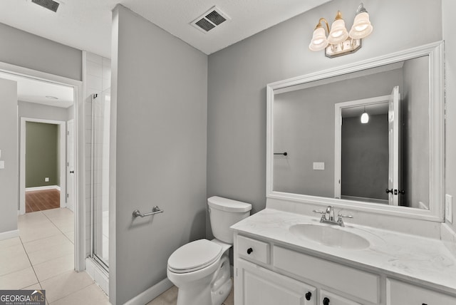 bathroom featuring tile patterned flooring, a textured ceiling, toilet, a shower with door, and vanity