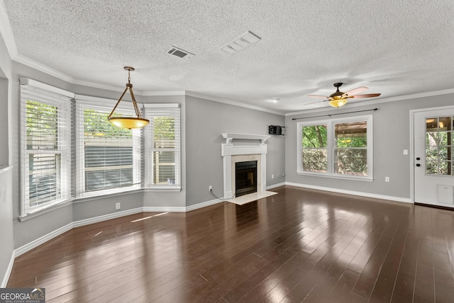 unfurnished living room with a wealth of natural light, dark hardwood / wood-style flooring, and a textured ceiling