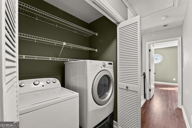 washroom featuring washing machine and clothes dryer and hardwood / wood-style floors