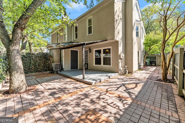 rear view of property with central air condition unit and a patio area