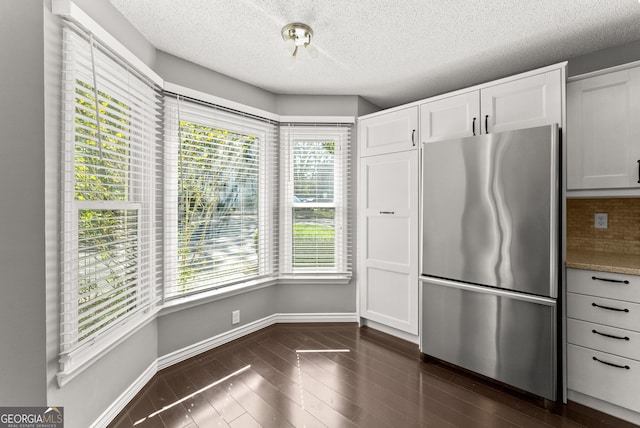 kitchen featuring white cabinets, stainless steel fridge, dark hardwood / wood-style floors, and plenty of natural light