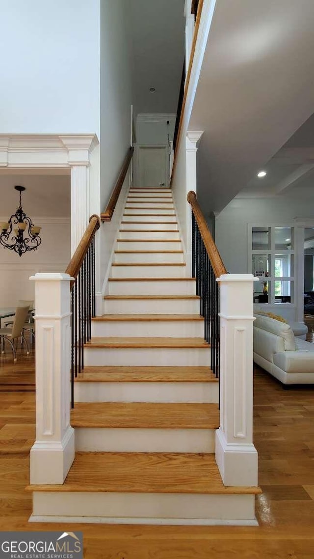 stairs featuring an inviting chandelier and hardwood / wood-style floors