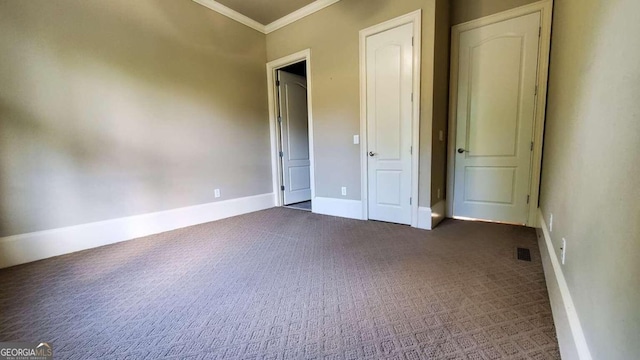 unfurnished bedroom featuring crown molding and dark colored carpet