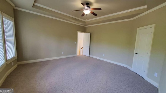 carpeted spare room with ornamental molding, ceiling fan, and a raised ceiling