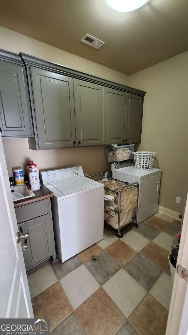 laundry area featuring sink and cabinets