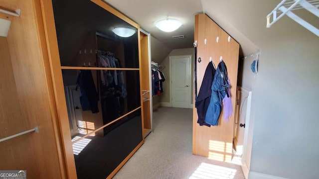 spacious closet featuring light carpet and vaulted ceiling