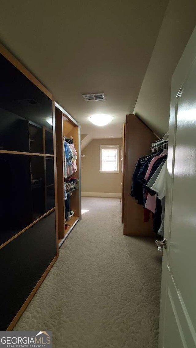 spacious closet with carpet and vaulted ceiling