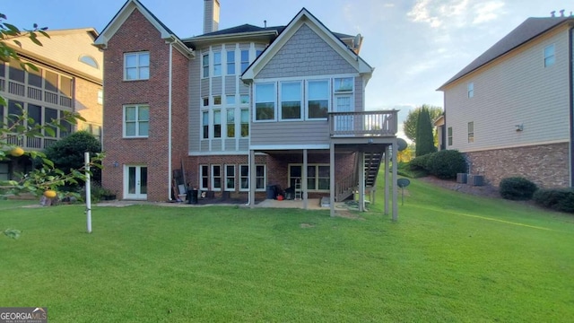 rear view of house featuring a patio and a lawn