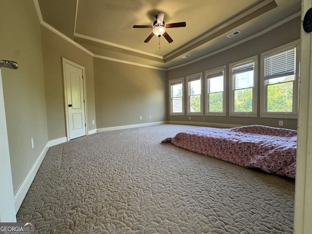 carpeted bedroom with a raised ceiling, baseboards, ornamental molding, and visible vents