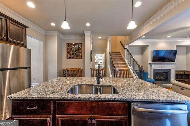 kitchen with light stone counters, decorative light fixtures, and appliances with stainless steel finishes