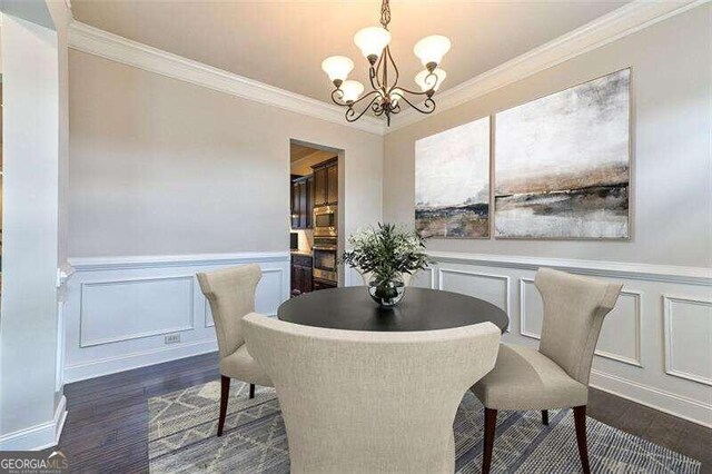 dining room with a notable chandelier, ornamental molding, and dark hardwood / wood-style flooring