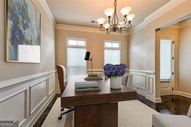 dining area with dark wood-type flooring, crown molding, and an inviting chandelier