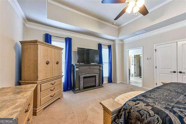 carpeted bedroom featuring ceiling fan, a closet, and ornamental molding