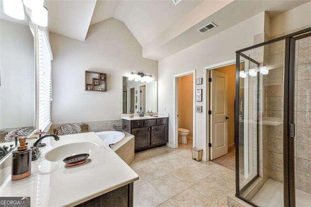 full bathroom with vanity, vaulted ceiling, plus walk in shower, tile patterned floors, and toilet