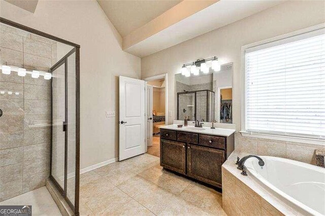 bathroom with a wealth of natural light, tile patterned floors, vanity, and independent shower and bath