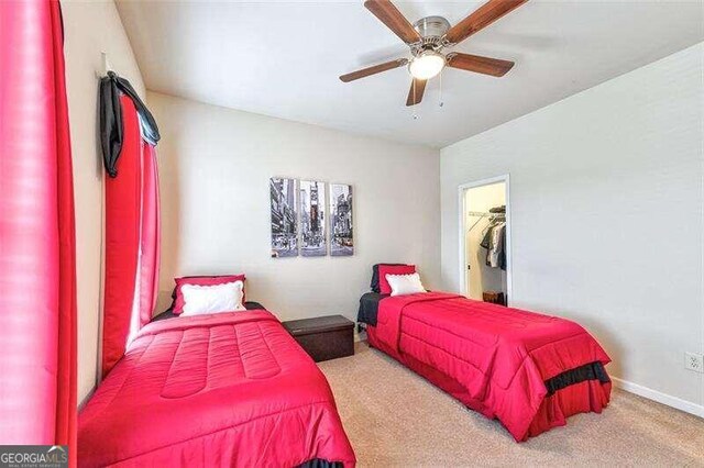 carpeted bedroom featuring ceiling fan, a closet, and a spacious closet