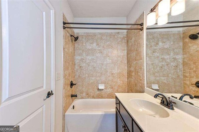 bathroom with tiled shower / bath and vanity