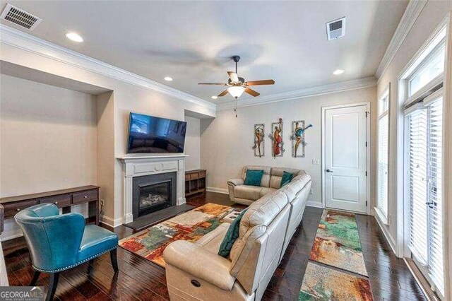 living room with crown molding, ceiling fan, and dark hardwood / wood-style flooring