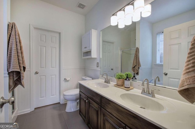 bathroom featuring tile patterned flooring, a shower with shower door, vanity, and toilet