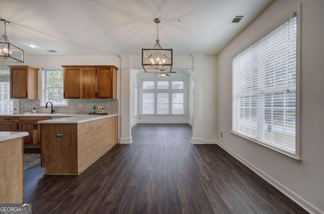 kitchen featuring pendant lighting, a notable chandelier, and dark wood-type flooring