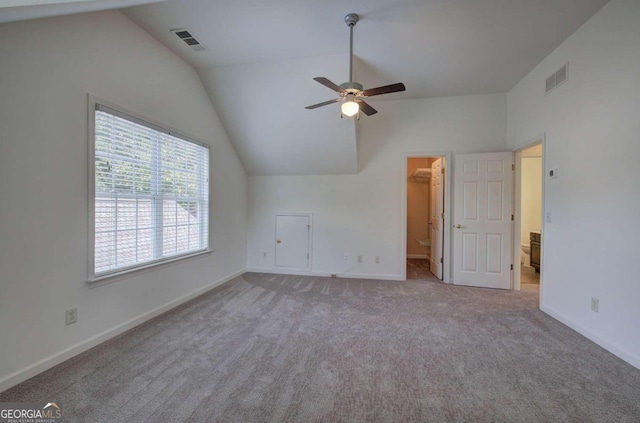 interior space featuring ceiling fan, light colored carpet, and lofted ceiling