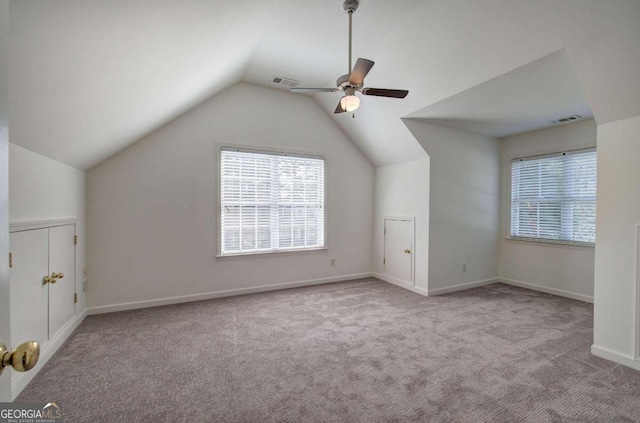 additional living space with light colored carpet, vaulted ceiling, and ceiling fan