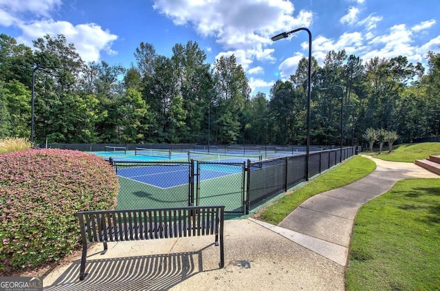 view of tennis court with a yard