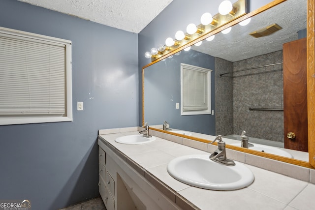 bathroom with vanity, a textured ceiling, and tile patterned floors