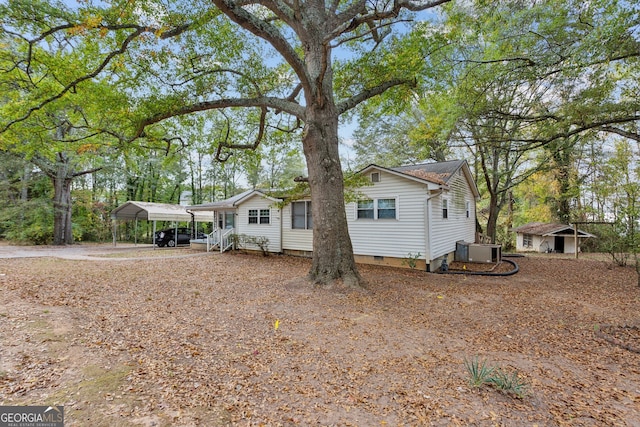 single story home featuring central AC unit and a carport