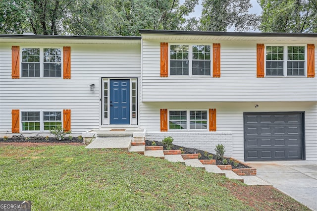 split foyer home with a garage and a front yard