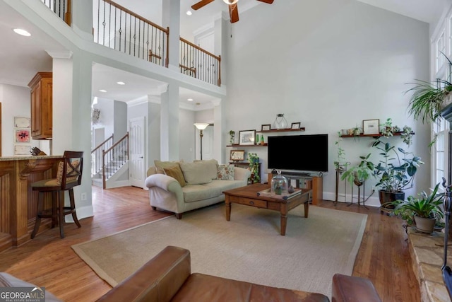 living room featuring high vaulted ceiling, ceiling fan, and wood-type flooring