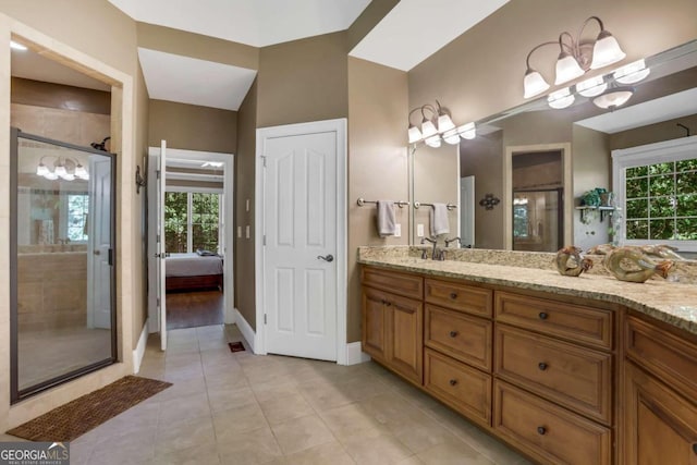 bathroom featuring tile patterned floors, a shower with shower door, and vanity