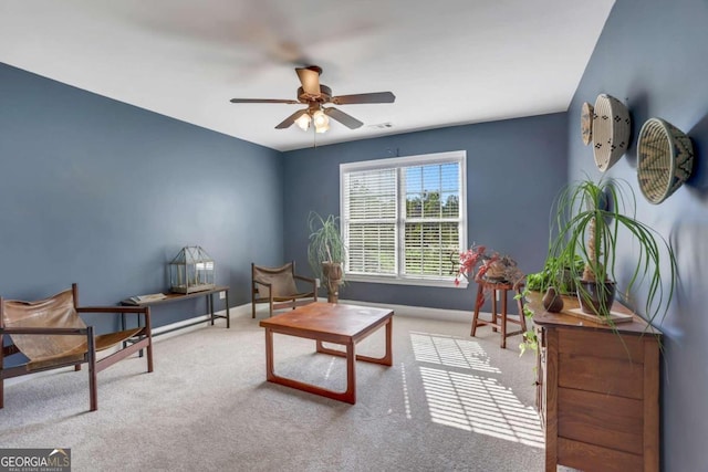 sitting room with ceiling fan and carpet