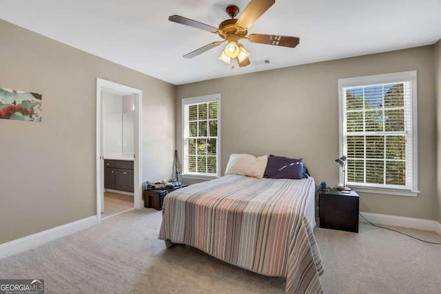 bedroom featuring light carpet, connected bathroom, and ceiling fan