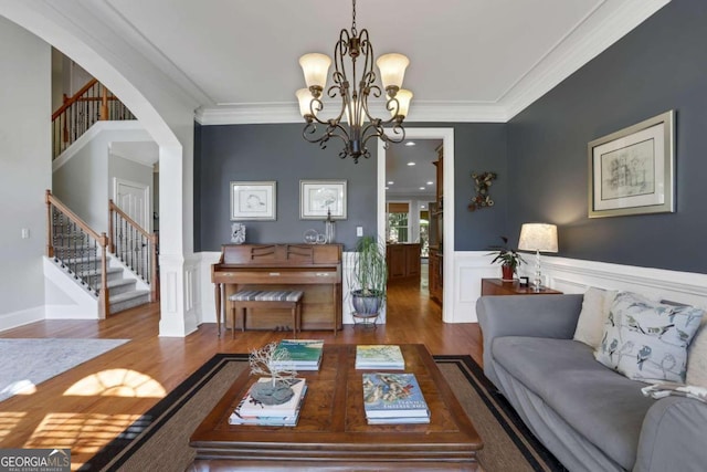 living room featuring crown molding, hardwood / wood-style floors, and a chandelier