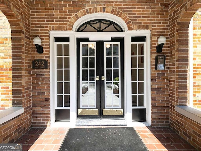 property entrance featuring brick siding and french doors