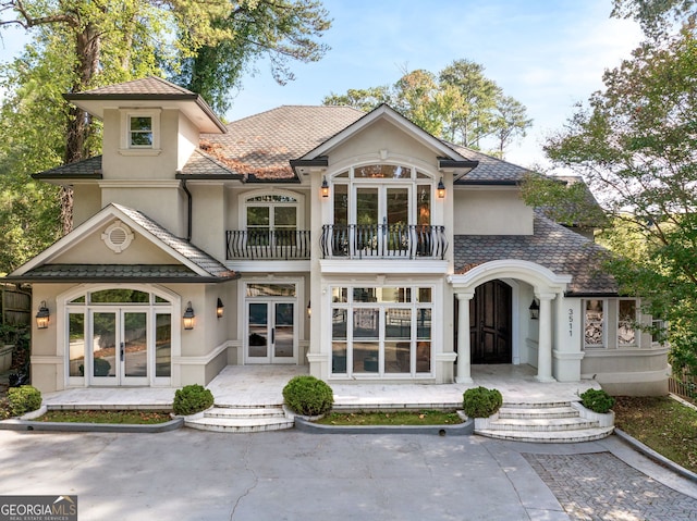 rear view of house featuring french doors and a balcony