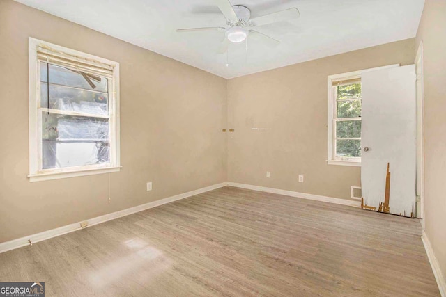 empty room with ceiling fan and light hardwood / wood-style flooring