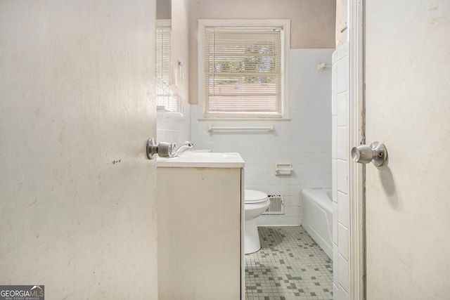 full bathroom featuring toilet, plus walk in shower, vanity, and tile walls