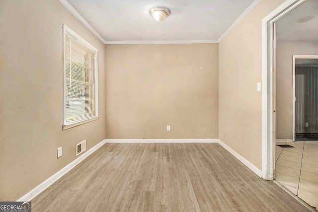 spare room featuring crown molding and light wood-type flooring