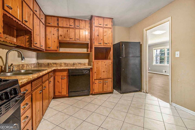 kitchen with light tile patterned flooring, black appliances, and sink