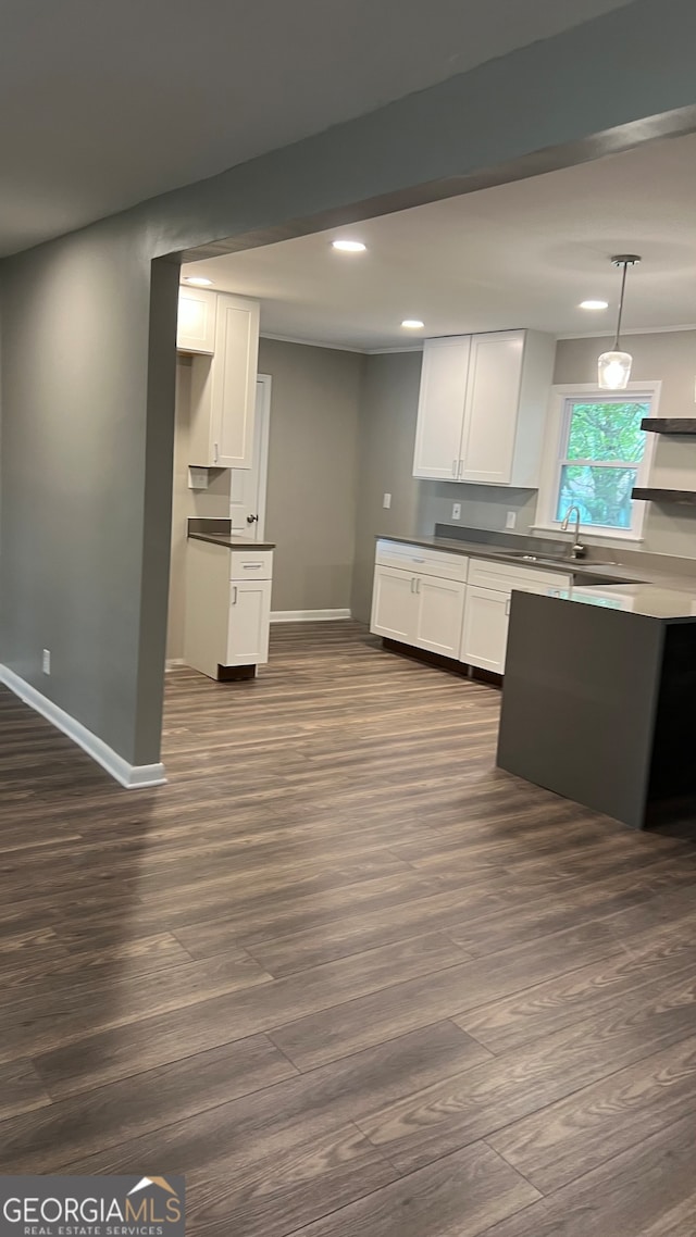 kitchen featuring sink, hanging light fixtures, white cabinetry, and dark hardwood / wood-style flooring